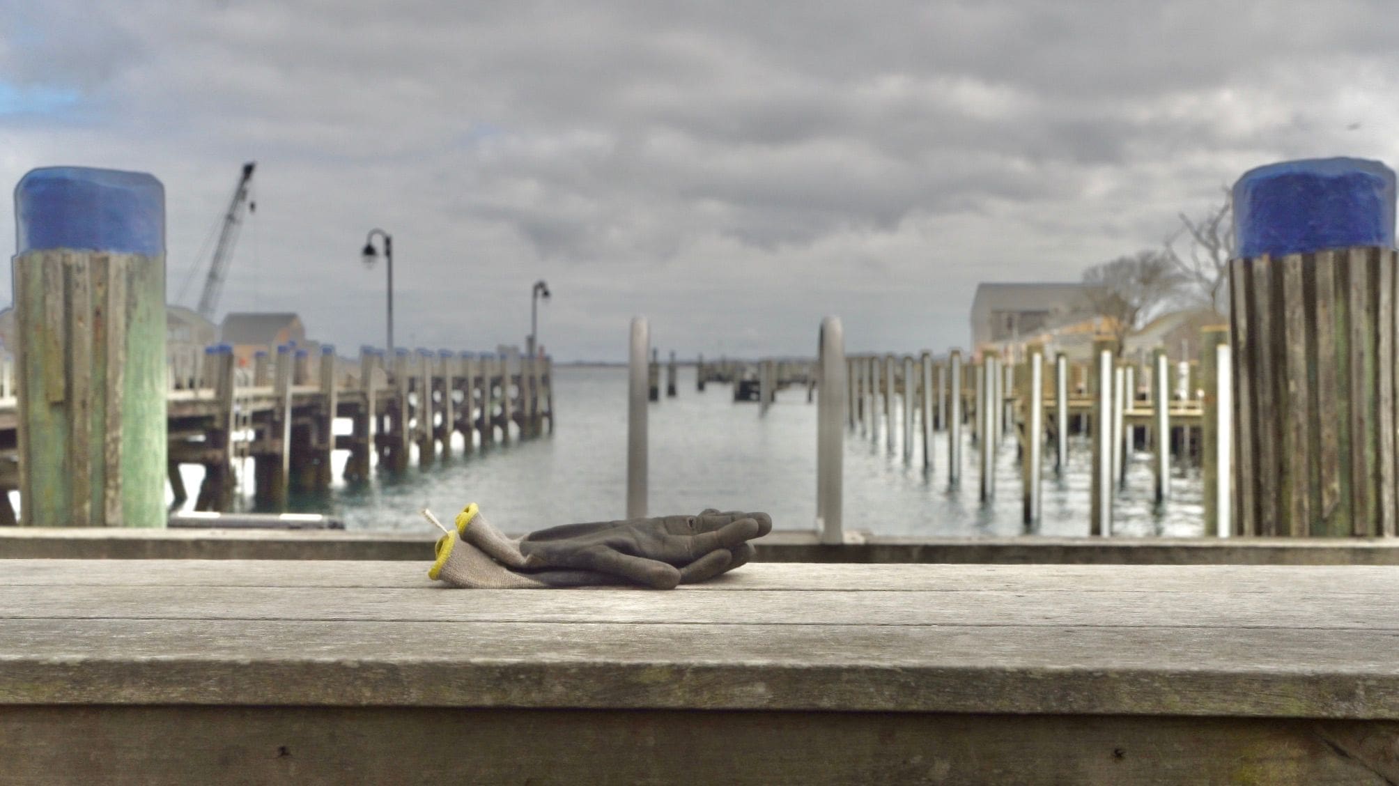 A person laying on the ground near water.