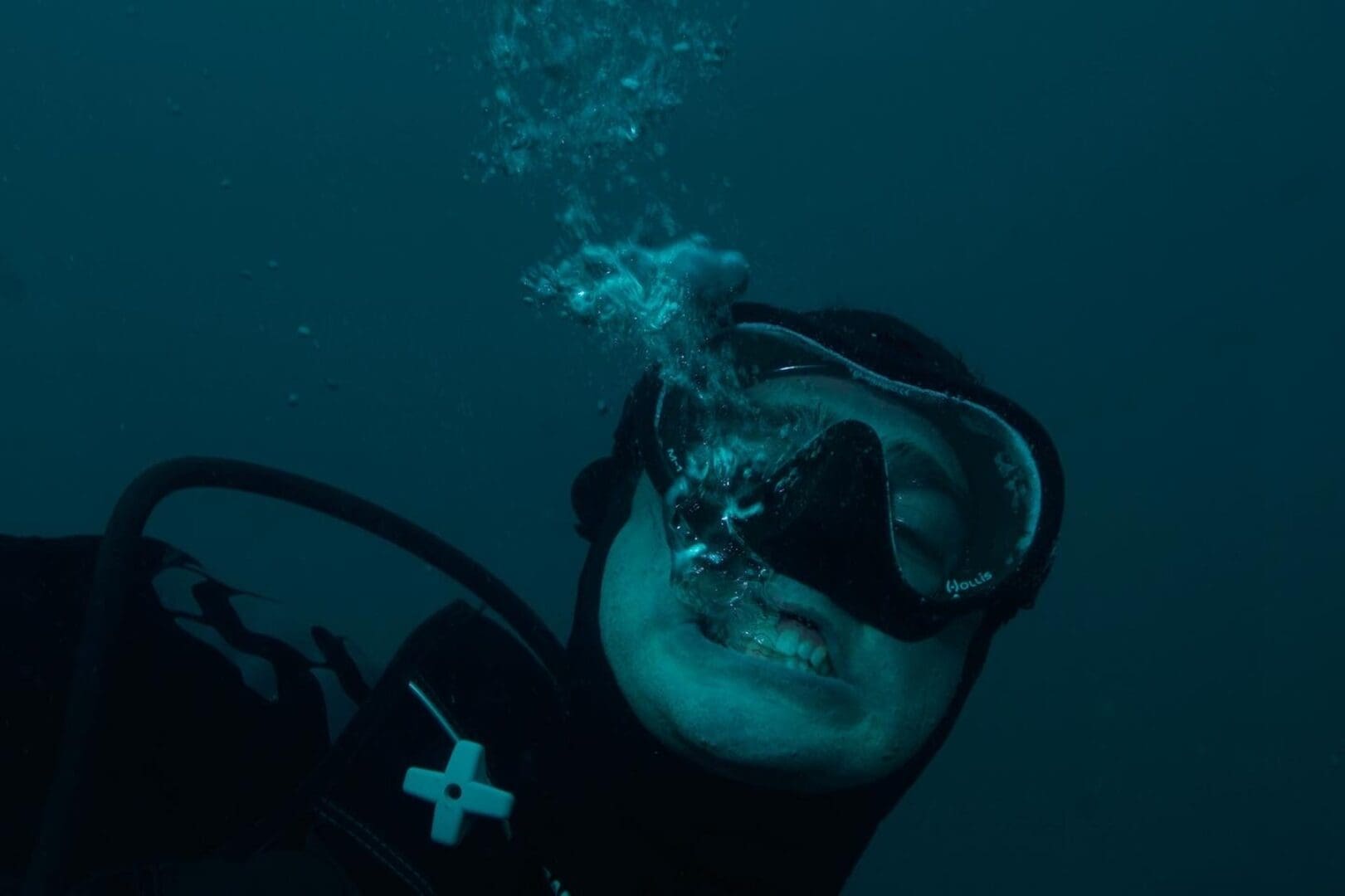 A man in black wetsuit with scuba mask and goggles.