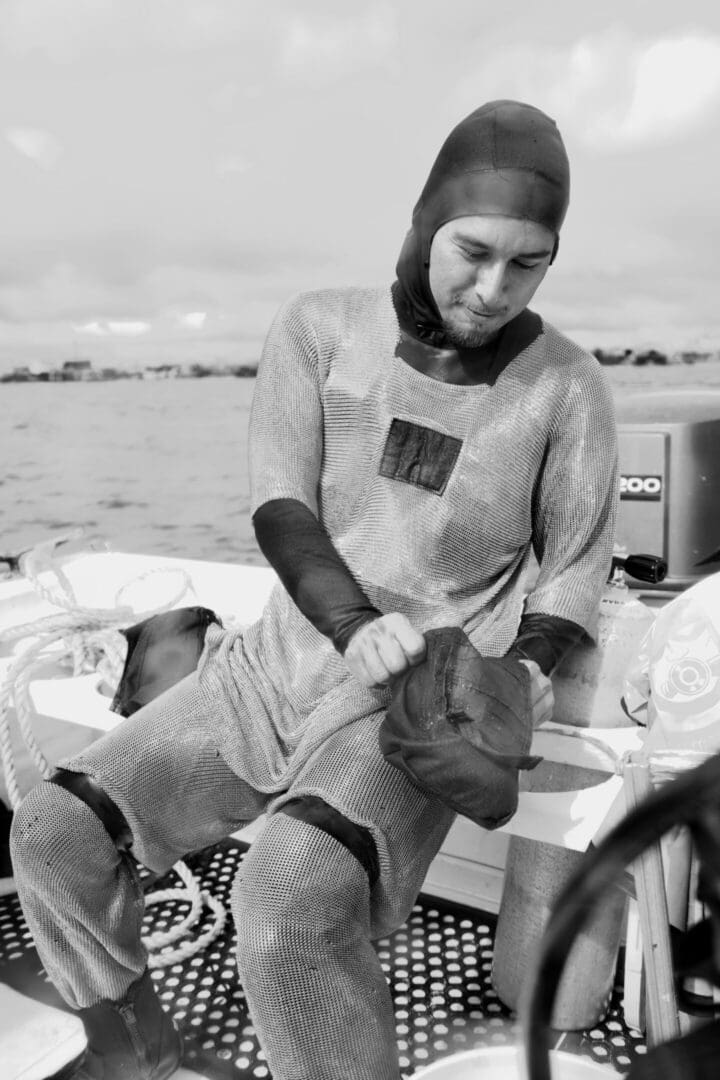 A woman in a helmet and a wet suit on the beach.