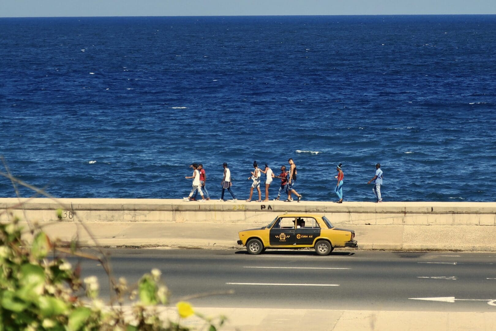 A car driving down the road near the ocean.