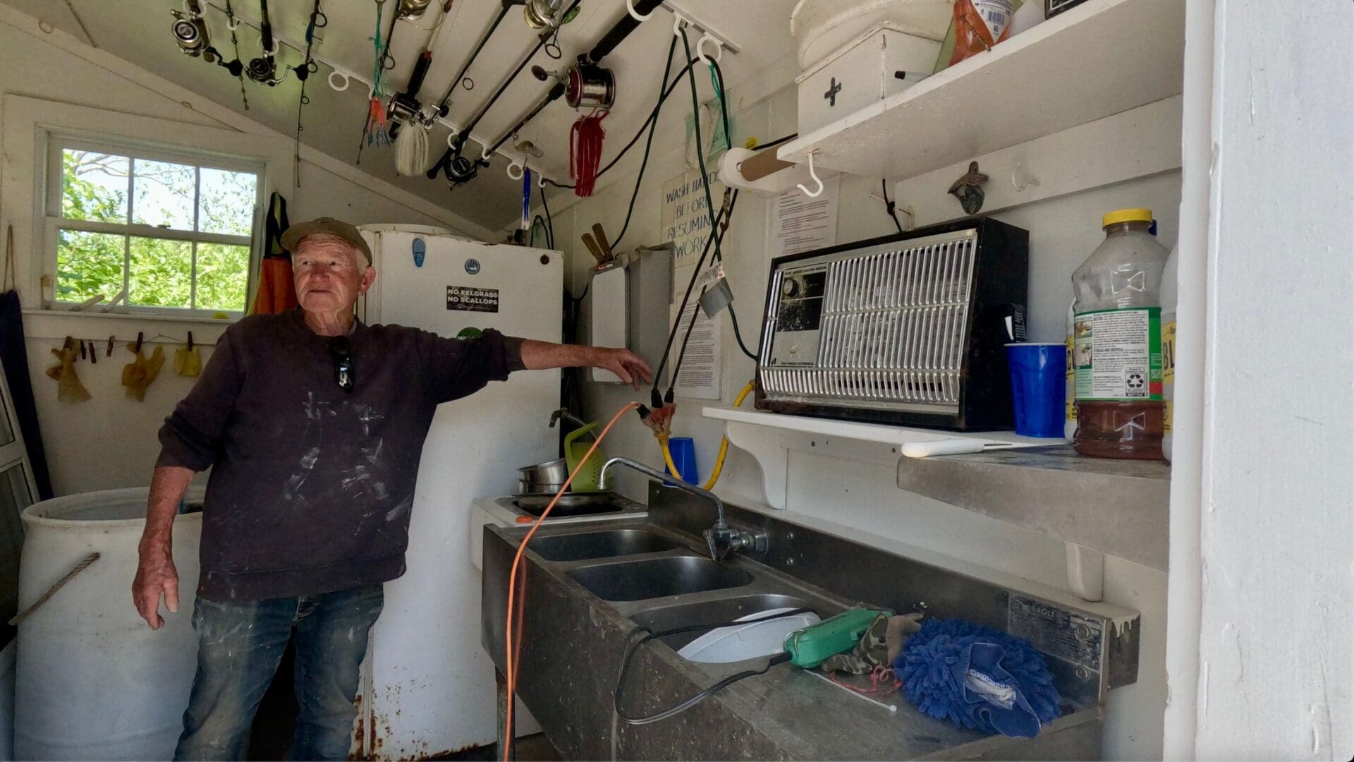 A man standing in front of some sinks and a microwave.