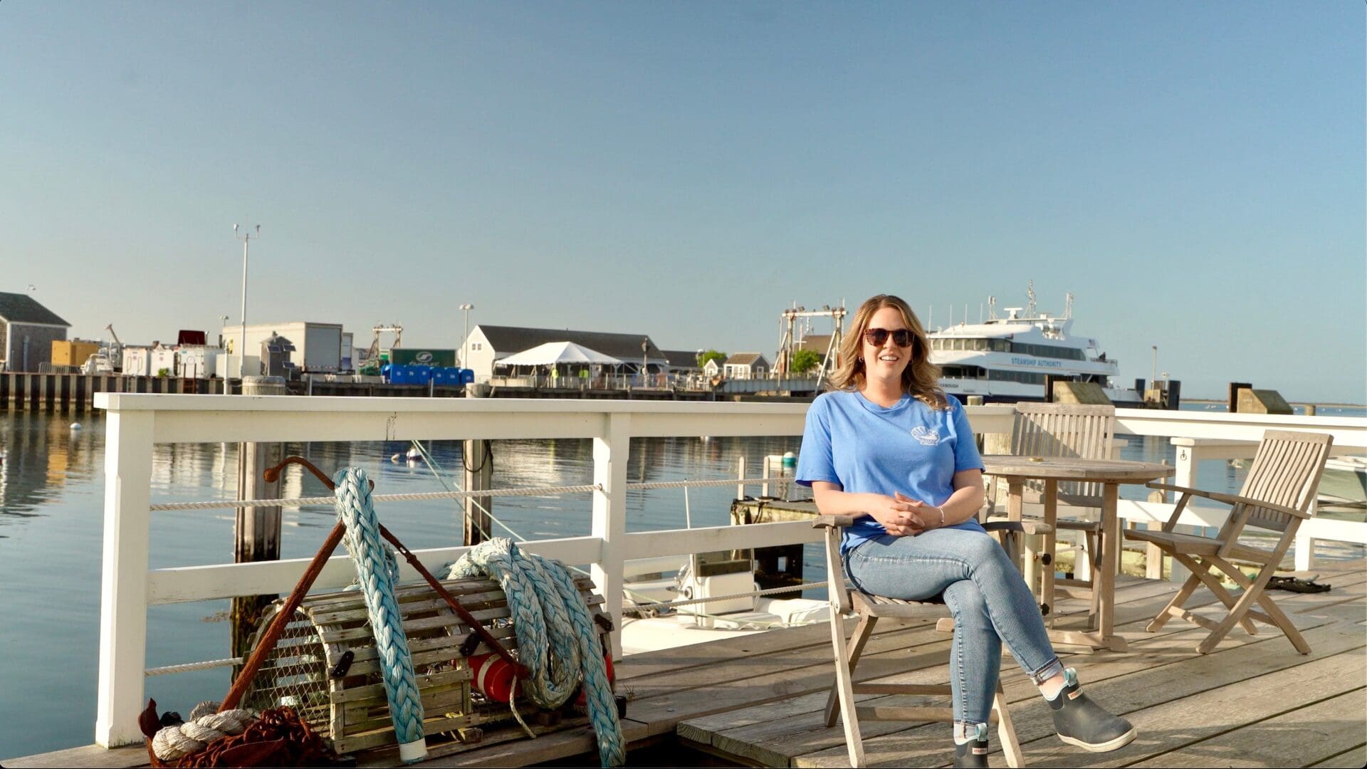 A woman sitting on top of a wooden deck.