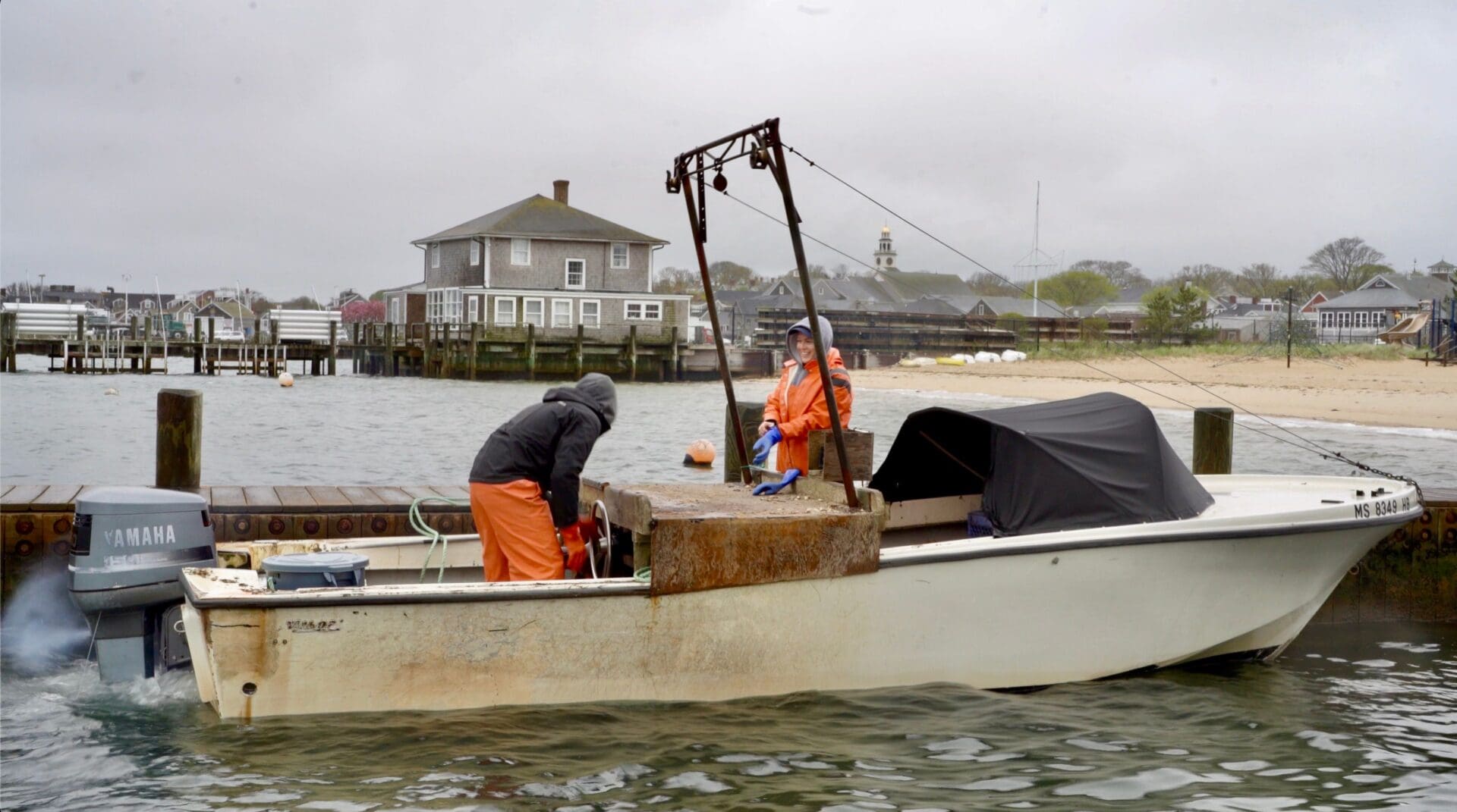 Two men in orange suits on a boat.