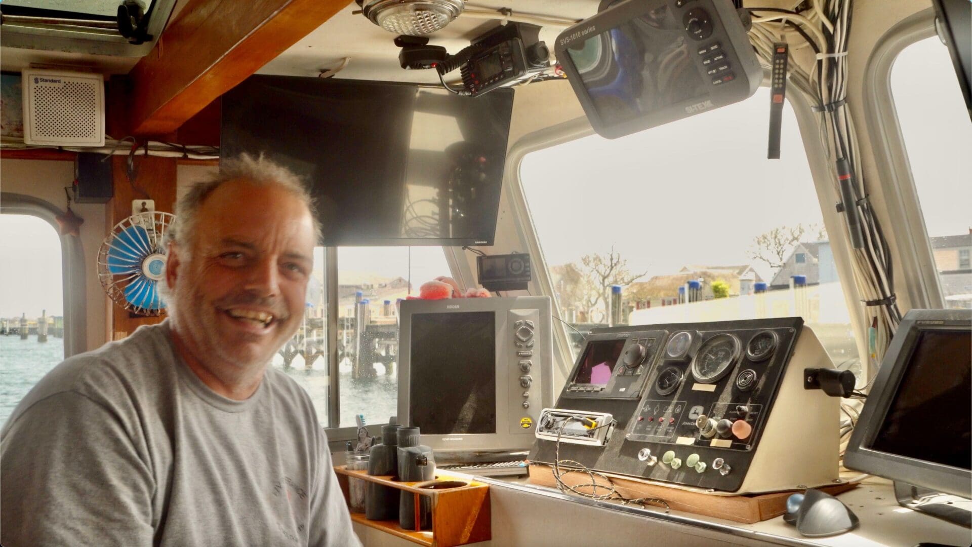 A man sitting in the back of a boat.